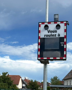 Speed checker light on a post labelled Vous roulez à